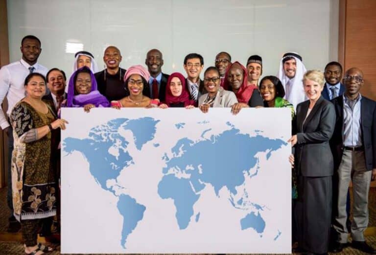 Diverse group holding large world map poster