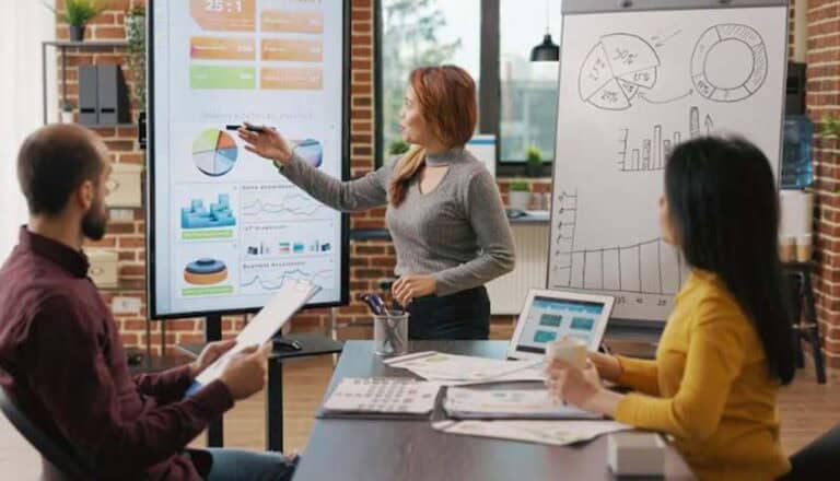 Businesswoman presenting charts to colleagues in office meeting
