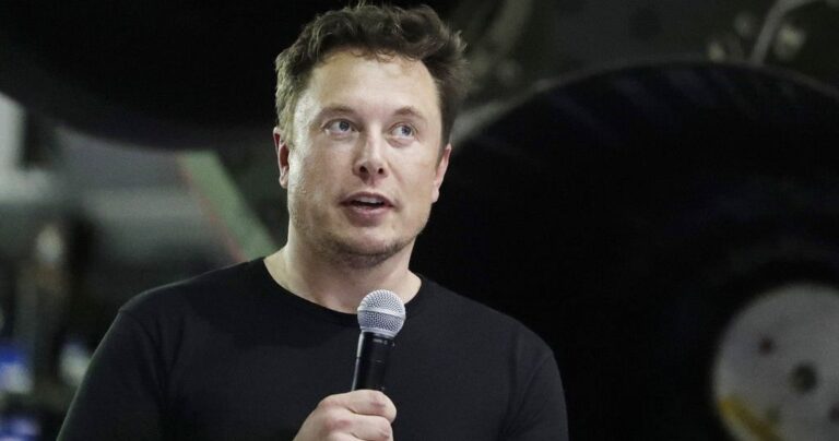 Man holding microphone speaking indoors