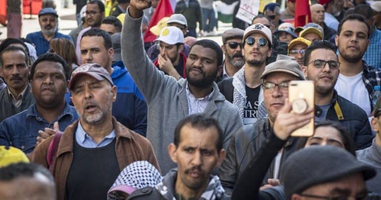 Crowd of men protesting, one raising fist