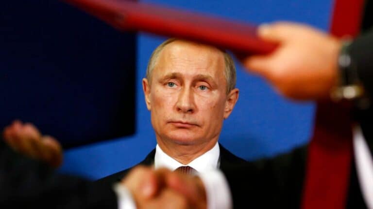 Man in suit at formal meeting, handshake foreground