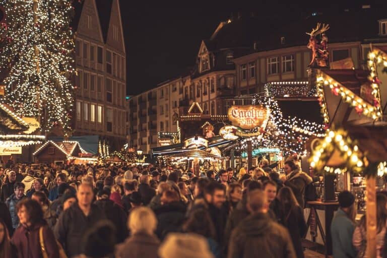 Crowded Christmas market at night with festive lights