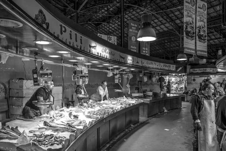 Fish market vendors behind seafood display counter
