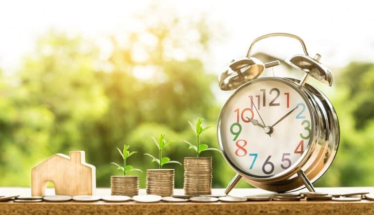 Alarm clock, coin stacks with plants and house model