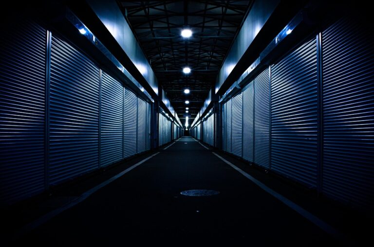 Dimly lit corridor with closed metal storage units