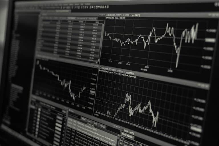 Computer screens displaying stock market charts and data