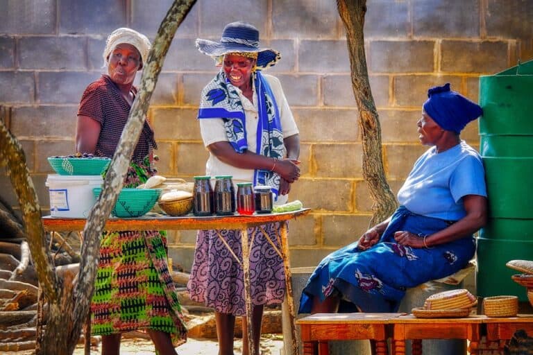 Three women at outdoor market food stall
