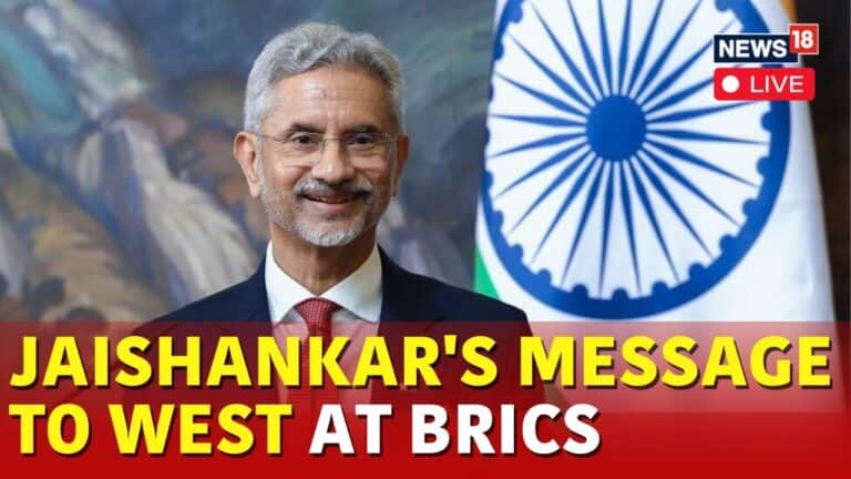 Man in suit before Indian flag news headline